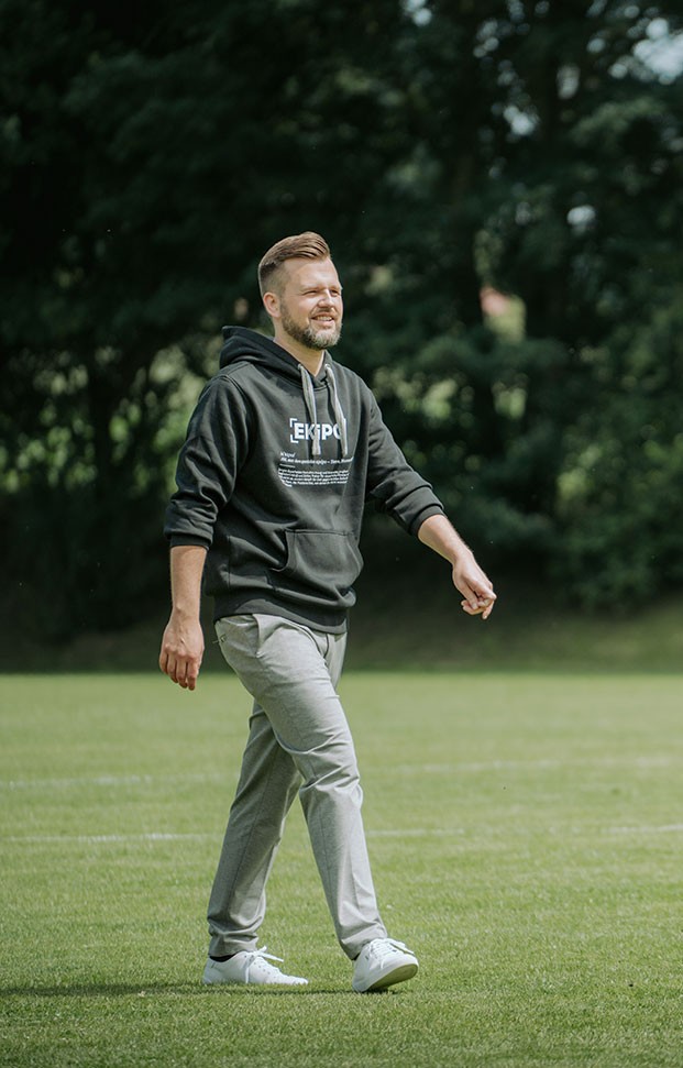 Mann geht am Fußballfeld - 